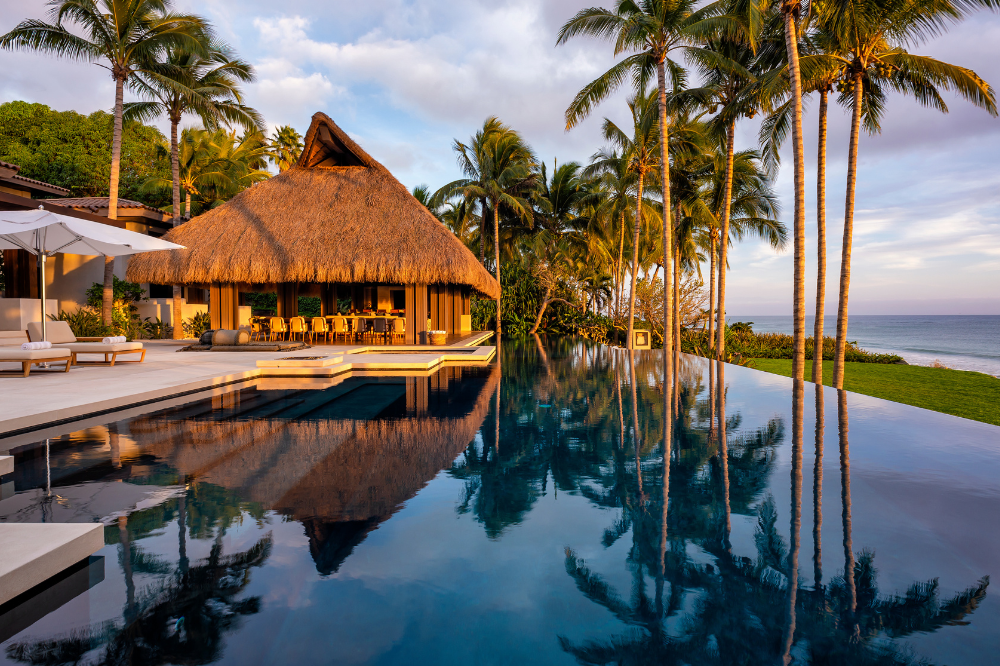 Sophisticated beachfront estate Casa del Oso in Punta Mita featuring an expansive infinity pool and outdoor luxury lounge areas.